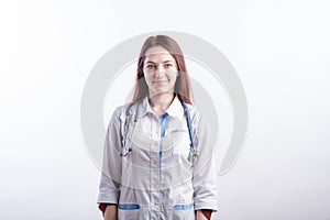 Portrait of a young female doctor in a white uniform in the studio on a white background.