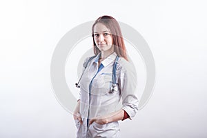 Portrait of a young female doctor in a white uniform in the studio on a white background.