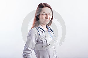 Portrait of a young female doctor in a white uniform in the studio on a white background.