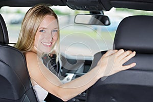 Portrait young female driver turning to look behind