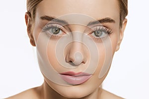 Portrait of young female fashion model with nude makeup isolated on white studio background. Spa, surgery, face lifting