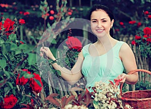 Portrait of young female holding a basket near roses in outdoor