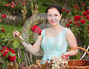 portrait of young female holding a basket near roses in outdoors