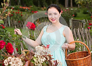 portrait of young female holding a basket near roses in outdoors