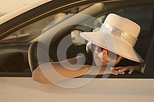 Portrait of a young female leaning on car window