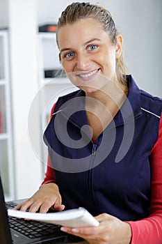 portrait young female manual worker using laptop