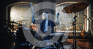 Portrait of a Young Female Playing Drums During a Band Rehearsal in a Loft Studio During an Evening