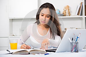 Portrait of young female sitting and writing