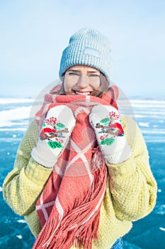 Portrait of a young female wonderer in fashionable hat and mittens and scarf looking in camera