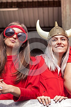 Portrait of young females supporter fans dressed in red color