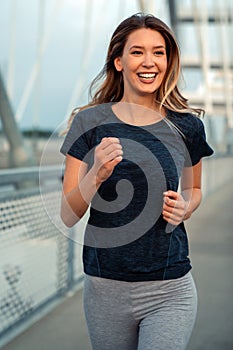 Portrait of young fit attractive happy fitness woman in city. People healthy lifestyle concept.