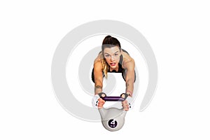 Portrait of a Young fitness woman doing intense core workout with kettlebell. Image