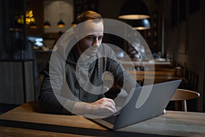 Portrait of young freelancer, man who using laptop in cafe