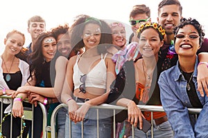 Portrait Of Young Friends In Audience Behind Barrier At Outdoor Music Festival