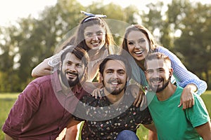 Portrait of young friends having good time in countryside. Group of happy people spending their weekend in nature