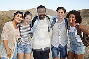 Portrait Of Young Friends Hiking Through Desert Countryside Together