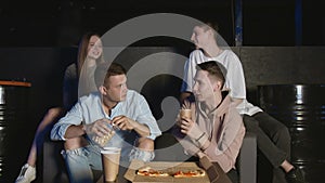 Portrait of young friends which eating popcorn during watching sport game on tv and talking about actions of players