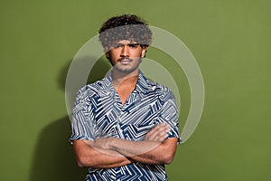 Portrait of young funny indian upset man in shirt folded arms when realized his family left him alone isolated on khaki