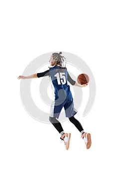 Portrait of young girl, basketball player in blue uniform training isolated over white studio background. Passing ball