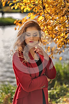 Portrait of a young girl with a beautiful make-up on closed eyes in an autumn landscape
