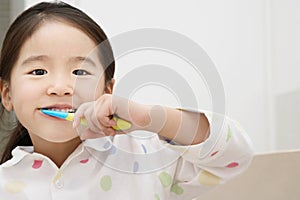Portrait of a young girl brushing her teeth