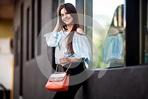 Portrait of Young girl dressed in a fashionable outfit. Posing against the window of the boutique