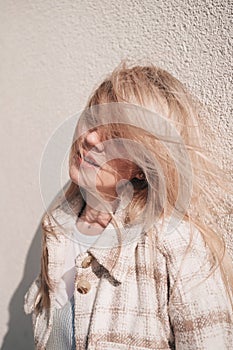 Portrait of a young girl with flying long hair covering her face.