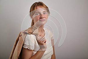 Portrait of young girl with ginger hair dressed in casual white blouse