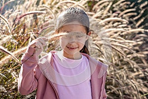 Portrait Of Young Girl Holding Pampas Grass In Front Of Her Eyes.