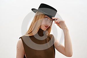 Portrait of young girl holding trendy hat on head