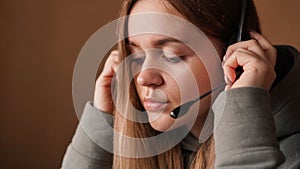 Portrait of a young girl in a hoodie and with a headset. Call center worker