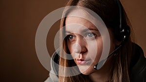 Portrait of a young girl in a hoodie and with a headset. Call center worker