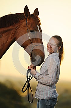 Portrait of young girl with horse at the sunset