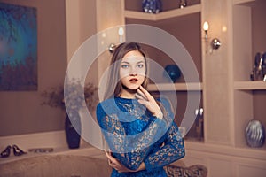 Portrait of young girl in hotel aparment dressed classic blue dress