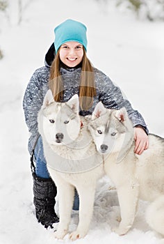 Portrait of a young girl with a husky puppies