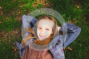 Portrait of young girl laying on grass outdoors