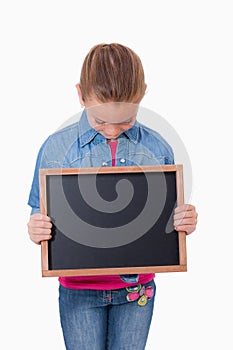 Portrait of a young girl looking at a school slate