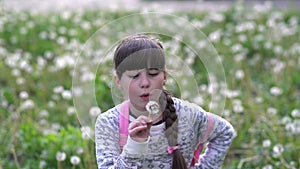 Portrait young girl at the outdoor in the green grass with dandelion.