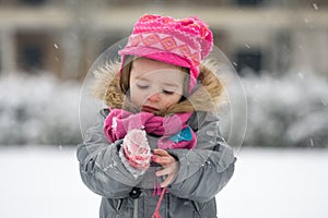 Portrait of a young girl outside in snowy weather dressed in win