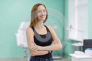 Portrait of young girl owner of beauty salon for nail care and hands with arms crossed, background beauty salon