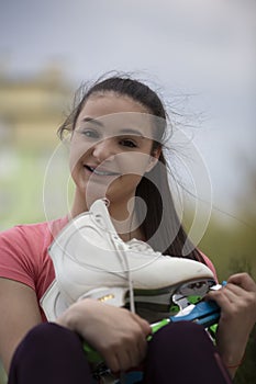 Portrait of young girl with pear of skates