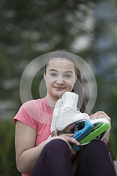 Portrait of young girl with pear of skates