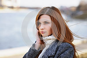 Portrait of a young girl with a pensive look on the waterfront
