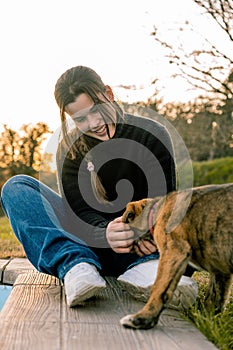 Portrait of a young girl playing with a dog puppy in the park in the afternoon photo