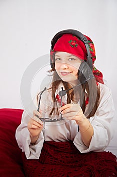 Portrait of young girl in red scarf, large headphones with microphone and black glasses. Woman who is radio or