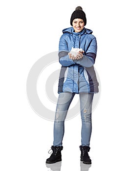 Portrait of a young girl with a smile in winter clothes with snow in hands.