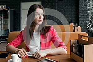 Portrait, young girl is spending time in a cafe for a cup of coffee. Business lunch