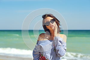 Portrait of a young girl in sunglasses on the sea coast
