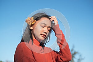 Portrait young girl wear orang swater with orang flower with blue sky background