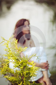 Portrait of young girl woman with cedar arborvitae